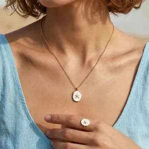 Nahaufnahme einer Halskette mit Seestern-Anhänger und passendem Ring aus Goldton.