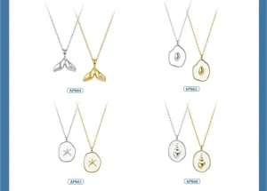 Detailansicht von Halsketten mit Anhängern wie Fischschwanz, Seestern und Muscheln in Gold Silber