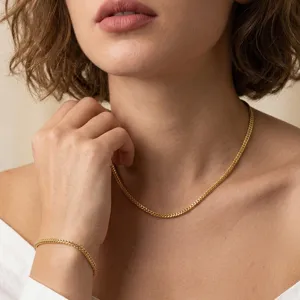 Dettaglio di elegante set di collana e bracciale a catena dorata su modella
