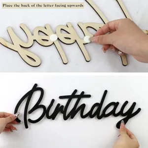 Vue détaillée des lettres en bois Happy Birthday montrant l'application de l'adhésif mural.