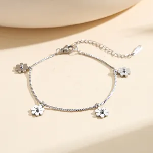 Close-up of stainless steel bracelet with delicate silver flower charms on a box chain