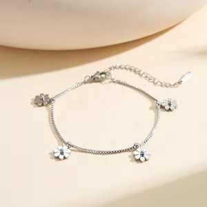 Detail view of a silver stainless steel box chain bracelet featuring delicate flower charms.