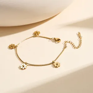 Detail view of a gold-plated stainless steel flower charm bracelet on a display stand