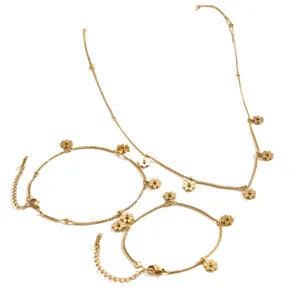 Gold stainless steel jewelry set featuring delicate flower charms necklace and bracelets