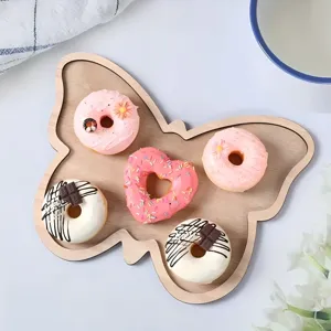 Wooden butterfly shaped serving tray detail showing creative design and neat pastry display.