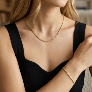 Dettaglio della collana e del bracciale a catena a coda di volpe dorata su modella.