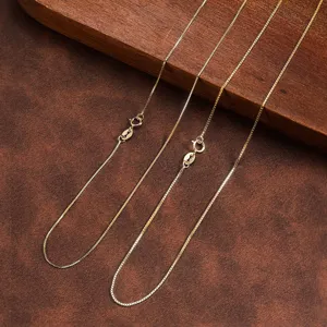 Primo piano di catene veneziane in argento 925 dorato su sfondo in legno e pelle