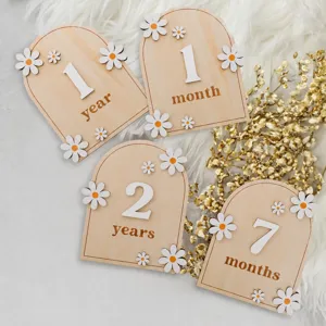 Wooden baby milestone cards detail view with daisy decor and monthly number photo props.