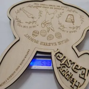 Detail de plateau de Pâques en bois, texte gravé au laser et mesure exacte du poids.