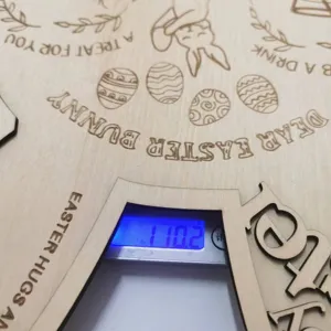 Plateau de lapin de Pâques en bois en détail avec texte de vœux et motifs gravés.