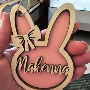 Gros plan d'un ornement de lapin de Pâques en bois personnalisé avec un prénom.
