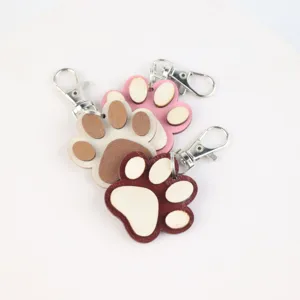 Wooden paw print keychain detail, cute animal design key ring accessory, close-up view.