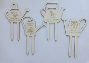 Detailed view of wooden watering can plant markers with funny engraved slogans and stakes.