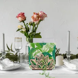 Detail van de houten servettenhouder met elegant lotus uitgesneden ontwerp op tafel.