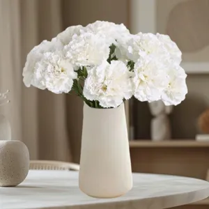 Detailansicht künstlicher Nelken Blumenstrauß in weißer Keramikvase für Raumdekoration.