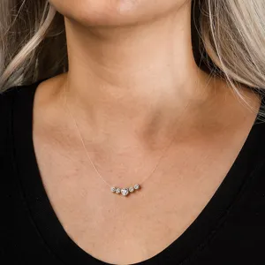 Close-up view of a heart and round cubic zirconia necklace on an invisible line.