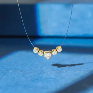Detail of invisible fishing line necklace with heart-shaped zirconia and gold plating.