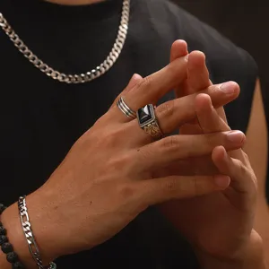 Gros plan d'une bague vintage pour homme avec agate noire et gravures détaillées.