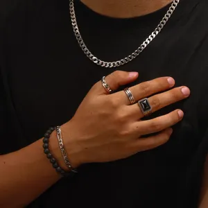 Détail d'une bague en argent pour homme avec pierre d'agate noire et bracelets.