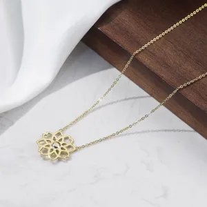 Detailaufnahme eines vergoldeten hohlen Lotus-Anhängers an einer zarten minimalistischen Kette