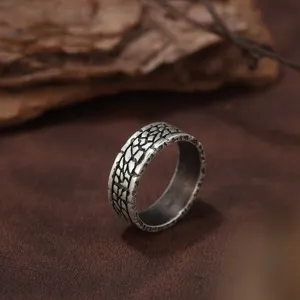 Gros plan d'une bague rétro en argent avec motif tressé oxydé et finition vieillie