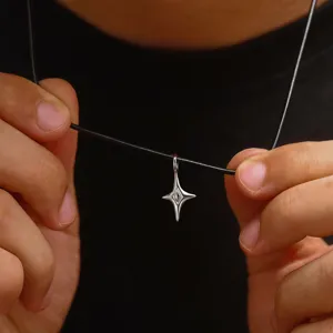 Nahaufnahme Detail aus Sterlingsilber vierzackiger Stern Anhänger an schwarzer Kette.