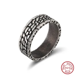 Gros plan d'une bague rétro en argent sterling S925 avec un motif tressé complexe.