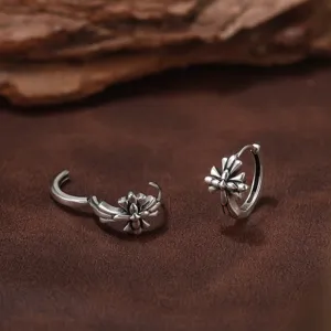 Gros plan montrant les détails floraux de ces boucles d'oreilles croix en argent S925.