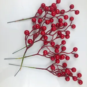 Vista dettagliata di tre rami di bacche rosse artificiali per decorazione natalizia