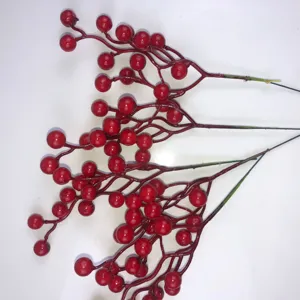 Primo piano di rami di bacche rosse artificiali per decorazioni natalizie