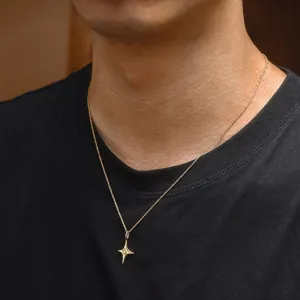 Detailaufnahme einer goldfarbenen Stern-Halskette, getragen zu einem T-Shirt.