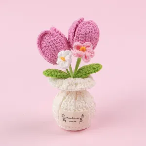 Detaillierte handgehäkelte rosa Tulpe in einer weißen Webvase auf rosa Hintergrund