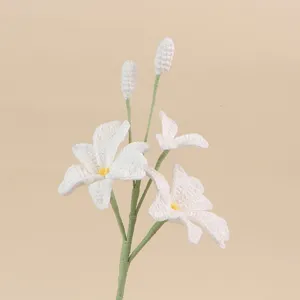 Detailaufnahme eines handgemachten weißen Häkel-Dendrobium-Orchideen-Blütenzweigs.