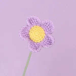 Macro dettaglio di un fiore afghano all'uncinetto viola e giallo fatto a mano con stelo