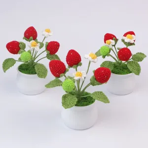 Set of three hand-knitted crochet strawberry potted plants with detailed yarn texture