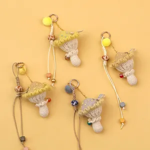 Detailed view of handmade crochet mushroom keychains in soft pastel yellow wool yarn