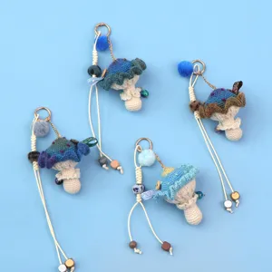 Detailed view of colorful handmade crochet mushroom pendants with fluffy pompoms and beads