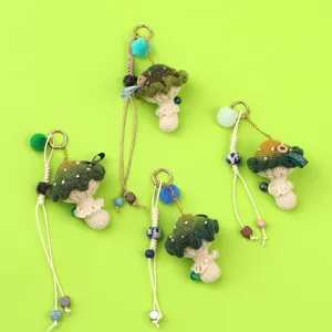 Detailed view of four handmade crochet mushroom keychains on a vibrant green background