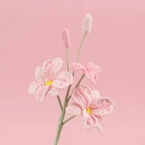Detaillierte Nahaufnahme einer handgehäkelten rosa Orchidee mit feiner Garnstruktur