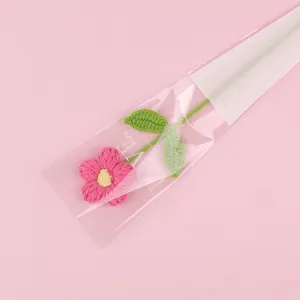 Detailed view of a handmade pink crochet puff flower in clear gift packaging with LOVE text.