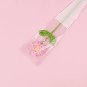 Close-up of handmade pink crochet puff flower in LOVE printed packaging