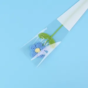 Detail shot of a hand-crocheted blue puff flower in elegant gift packaging.