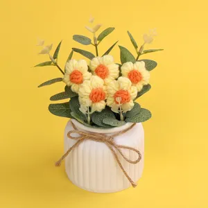 Handgehäkelte Puffblumen im weißen Keramiktopf mit einer rustikalen Juteschleife