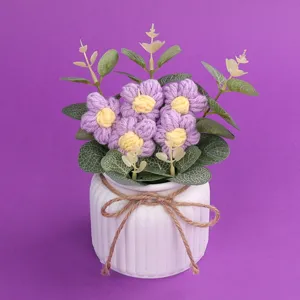 Detailansicht der handgestrickten lila Puffblumen in einem weißen gerippten Keramiktopf