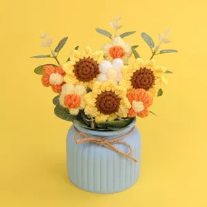 Handmade crochet sunflower bouquet in a blue vase on a yellow background gift detail