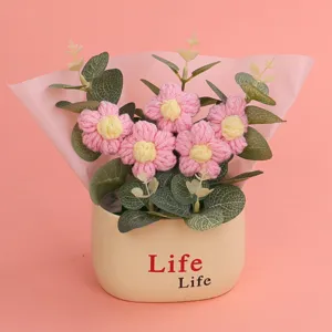 Detailed macro view of handmade crochet puff flowers in a cream pot with 'Life' text.