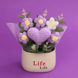 Close-up of handmade crochet purple heart and puff flowers in a beige Life pot
