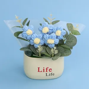 Detailed view of a handmade blue crochet puff flower bouquet in a white pot