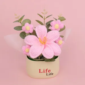 Handmade crochet pink flower potted plant with tulip puff flowers on pink background.