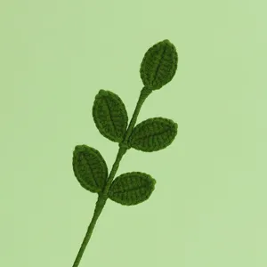 Vista macro di un ramo di foglie lavorato a maglia verde scuro con trama di filato fine
